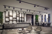Modern black LED track spotlights on ceiling in stylish bar and lounge area with wood and concrete