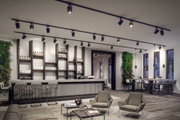 Moderne schwarze LED-Schienenstrahler an Decke in stilvollem Bar- und Loungebereich mit Holz und Beton
