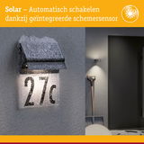 Zonneverlichte huisnummer 27c met geïntegreerde schemersensor en sneeuw op grijze muur buiten