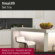 Moderne weiße Kücheninsel mit beleuchtetem Sockel und transparentem Barhocker im minimalistischen Design