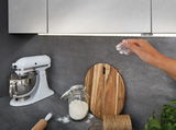 Kitchen counter with white stand mixer, wooden board, jar of flour and grey LED under-cabinet light.