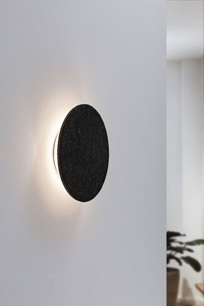 Rund væglampe med sort filtcover og varmt hvidt LED-lys til moderne opholdsrum.