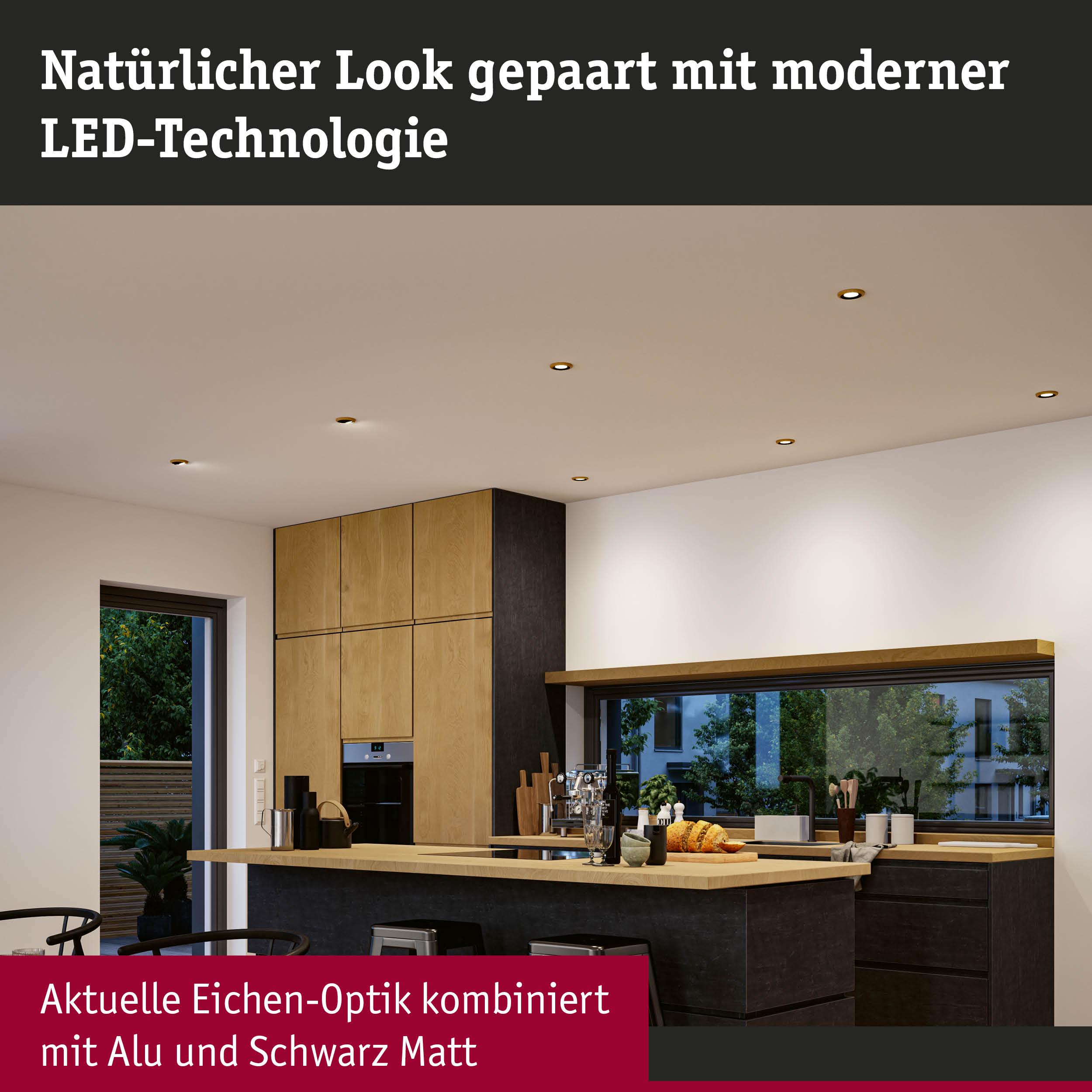 Moderne Küche mit aktueller Eichen-Optik, Aluminium und mattem Schwarz, beleuchtet mit LED-Spots.