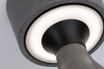 Close-up van grijze metalen lamp met ronde witte LED-lichtkring en zwarte binnenkegel