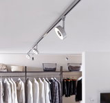 Modern white LED track light with round spotlights in a walk-in closet setting.