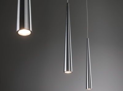 Drie slanke hanglampen van geborsteld zilverkleurig aluminium met warm wit LED-licht.