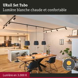 Suspensions noires modernes et spots avec lumière blanc chaud au-dessus d'une table en bois dans la salle à manger