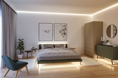 Chambre moderne avec éclairage LED, lit vert et mobilier minimaliste en bois et tissu