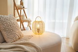 Round beige seat with macrame cushion and round bamboo lantern for cozy living room lighting