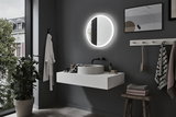 Moderne badkamer met ronde LED-spiegel, grijze muur, witte wastafel en houten kruk met handdoeken