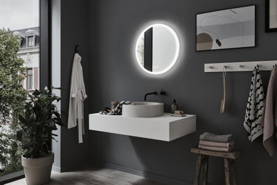 Salle de bain moderne avec miroir LED rond, mur gris, lavabo blanc et tabouret en bois avec serviettes