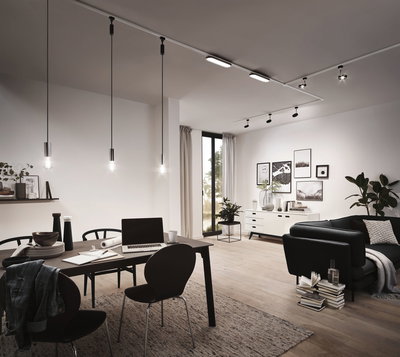 Salon moderne avec suspensions noires et éclairage LED sur rail, sol en bois et décoration minimaliste