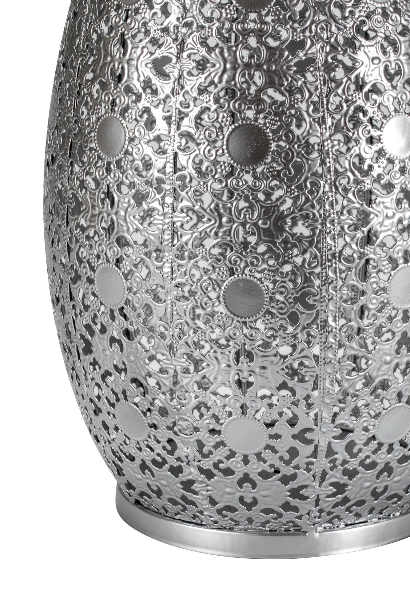 Close-up of silver metal lampshade with intricate floral pattern and round decorative elements