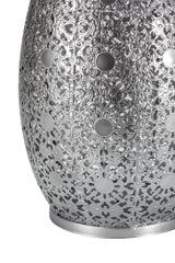 Close-up of silver metal lampshade with intricate floral pattern and round decorative elements