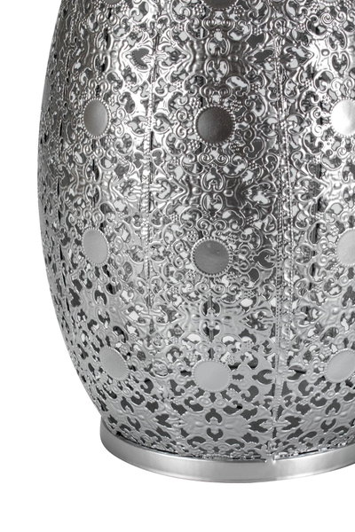 Close-up of silver metal lampshade with intricate floral pattern and round decorative elements