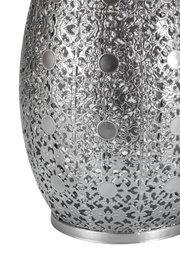 Close-up van zilveren metalen lampenkap met ingewikkeld bloemmotief en ronde decoratieve elementen