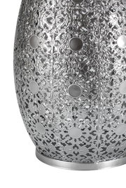 Close-up of silver metal lampshade with intricate floral pattern and round decorative elements