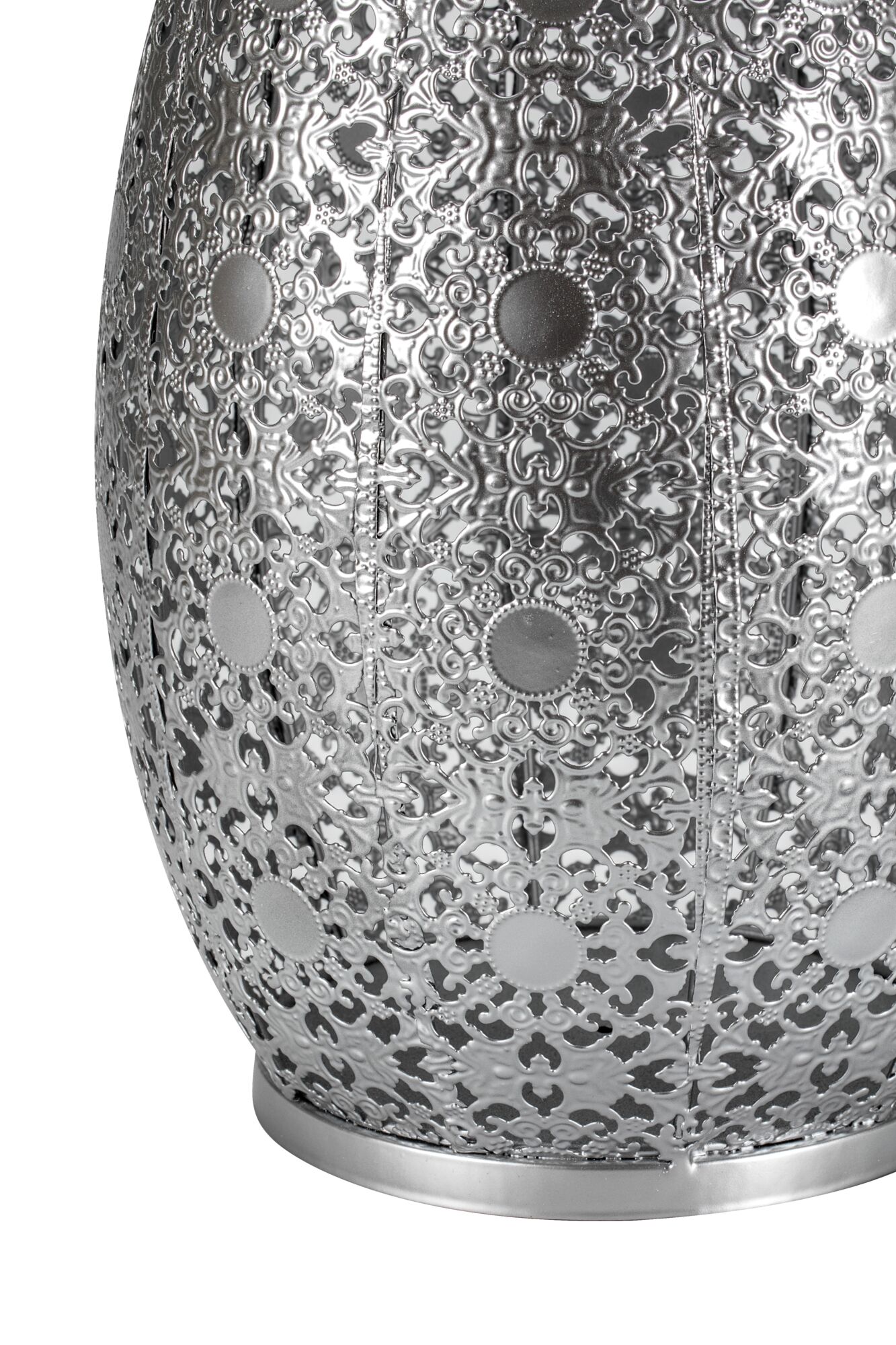 Close-up of silver metal lampshade with intricate floral pattern and round decorative elements