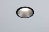 Round recessed spotlight with black frame and silver reflector in white ceiling, LED lighting