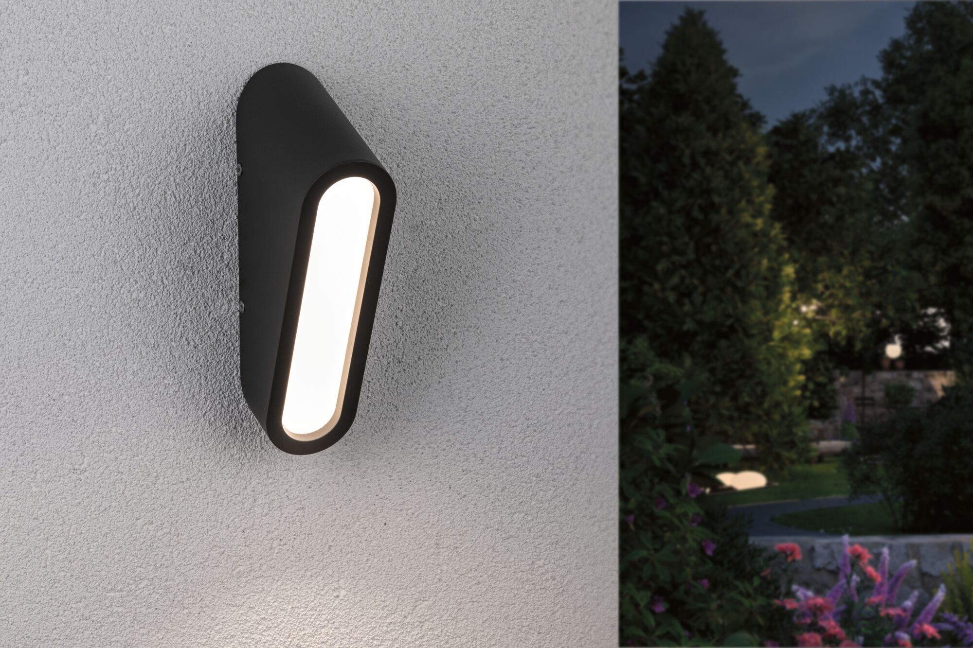 Schwarze LED-Außenwandleuchte mit länglichem Design an weißer Wand, Gartenbeleuchtung bei Nacht