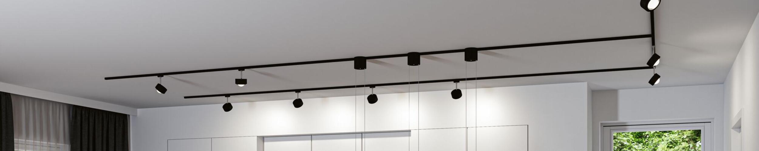 Zwart URail railsysteem met meerdere LED-spotlights aan witte plafond voor moderne verlichting
