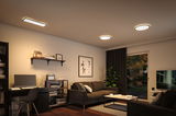 Modernes Wohnzimmer mit schwarzem Sofa, Schreibtisch und warmweißen LED-Deckenleuchten für gemütliche Beleuchtung