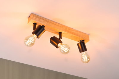 Deckenleuchte mit drei schwarzen Metalllampen an Holzleiste, warmweißes LED-Licht für Wohnräume