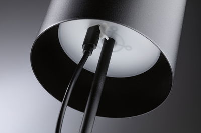 Lampadaire en métal noir avec câble et diffuseur blanc pour un intérieur moderne.