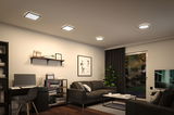 Modern living room with black furniture and square and round ceiling lights emitting warm white light