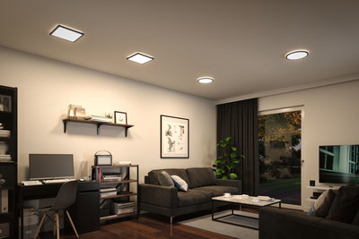 Modernes Wohnzimmer mit schwarzen Möbeln und quadratischen sowie runden Deckenleuchten in warmweißem Licht