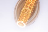 Warm glowing LED bulb with golden glass and decorative light pattern for ambient home lighting