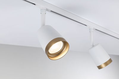 Modern white LED spotlight with gold trim on track system for focused room lighting