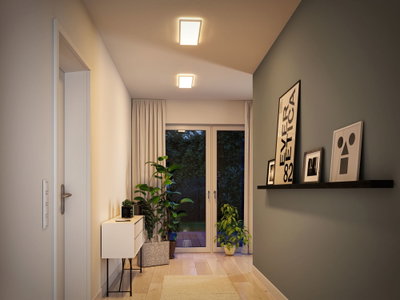 Moderne gang med to rektangulære loftslamper, der udsender varmt hvidt lys og minimalistisk indretning