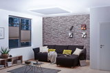 Modernes Wohnzimmer mit indirekter MaxLED Deckenbeleuchtung in Tageslichtweiß und grauer Steinwand.