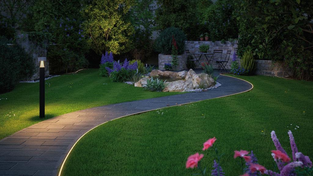 Illuminated garden path with black LED bollard and indirect ground lighting for outdoor spaces.