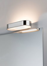 Modern chrome LED wall light with warm white illumination above a mirror for bathroom lighting