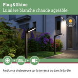 Lampes extérieures noires modernes avec lumière blanche chaude éclairant le chemin de jardin et la terrasse