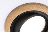 Close-up of round recessed spotlight with wooden frame and black inner ring for modern LED lighting