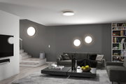Modern living room with round white LED ceiling and wall lights on grey wall and grey sofa