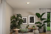 Salon moderne avec fauteuil vert, table d'appoint en bois, grandes plantes d'intérieur et plafonnier