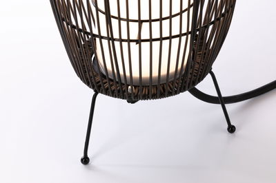 Gros plan sur un pied en métal noir avec abat-jour tissé et ampoule LED blanche pour éclairage moderne.
