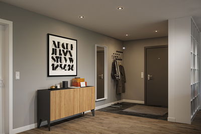 Moderner Flur mit warmweißen LED-Einbaustrahlern in grau und Holzoptik für stilvolle Beleuchtung