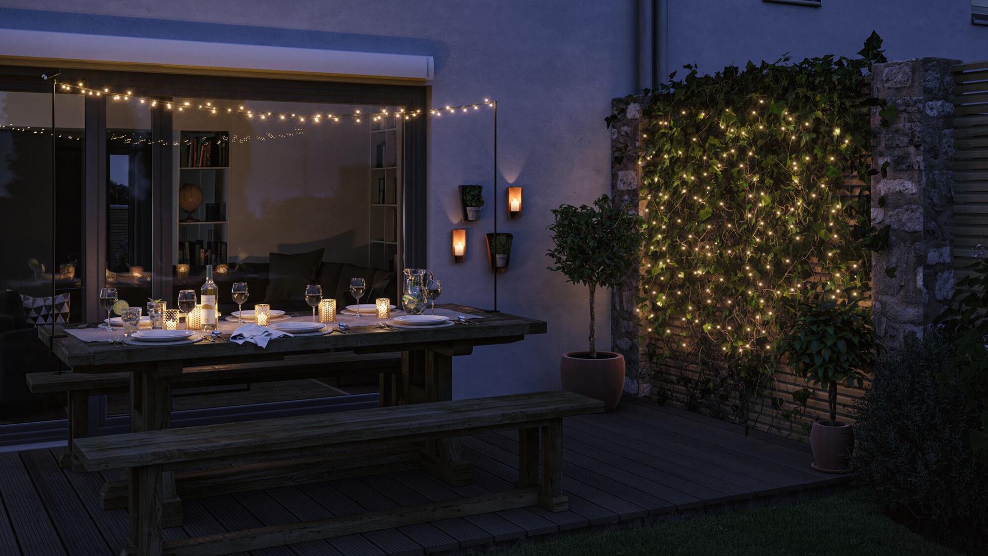 Gemütliche Terrasse mit Solarleuchten, warmweißen Lichterketten und Kerzen für stimmungsvolle Außenbeleuchtung.