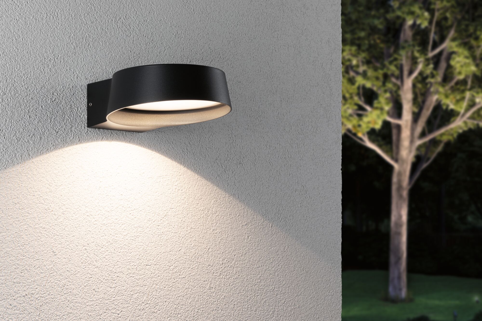Black aluminum wall light with warm white LED on exterior wall, modern outdoor garden lighting