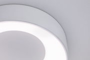 Gros plan d'un plafonnier LED rond blanc avec lumière diffuse et design moderne