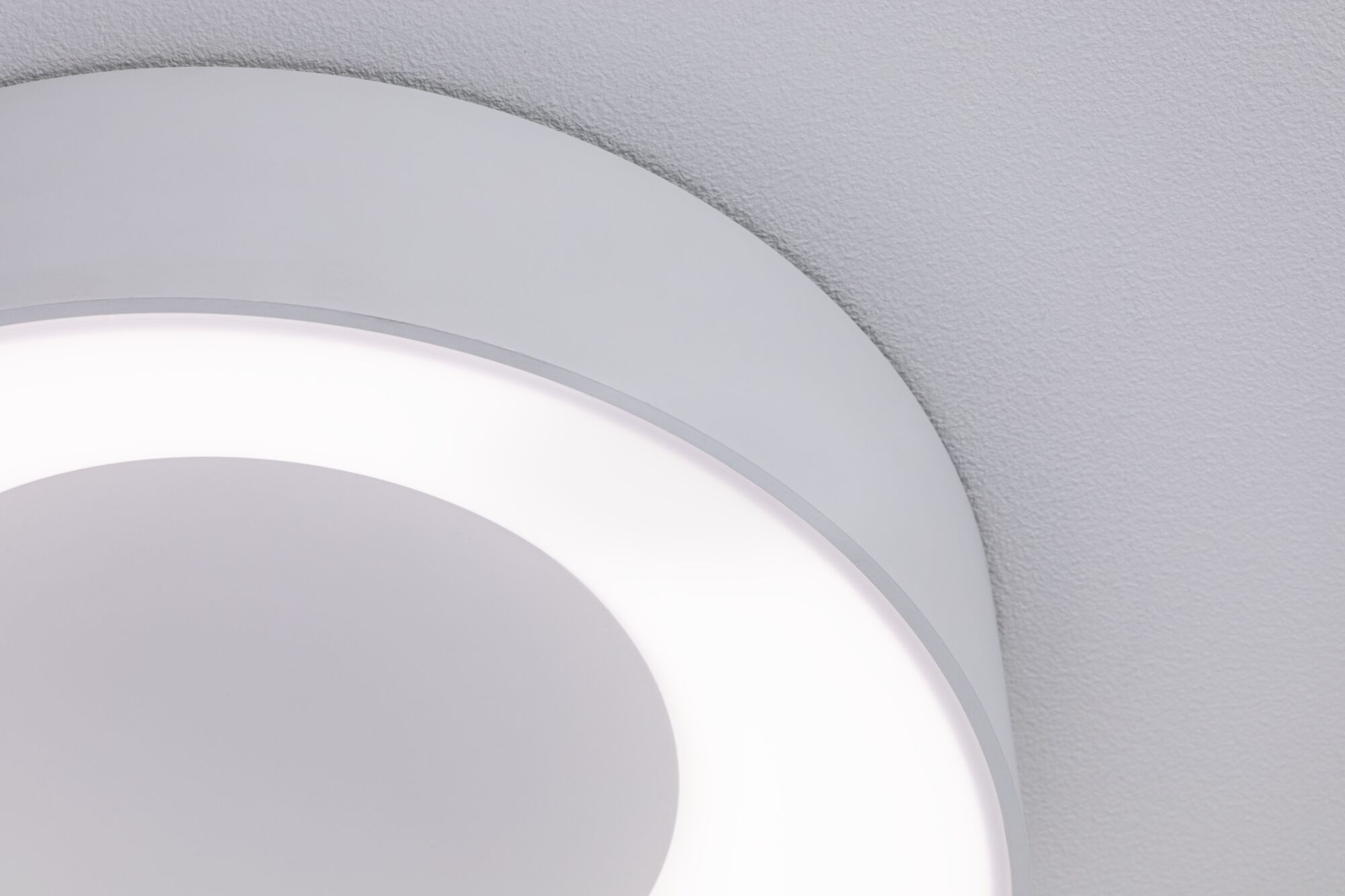 Gros plan d'un plafonnier LED rond blanc avec lumière diffuse et design moderne