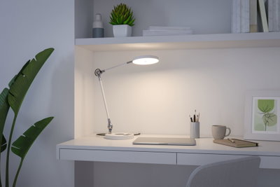 Lampe de bureau LED blanche avec bras réglable sur espace de travail moderne avec ordinateur portable et tasse
