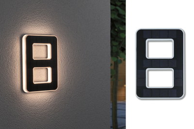 Modern black solar LED wall light with two rectangular cutouts, outdoor lighting for energy-efficient illumination