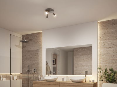 Modernes Badezimmer mit dreiflammiger Deckenleuchte aus gebürstetem Metall und indirekter LED-Beleuchtung