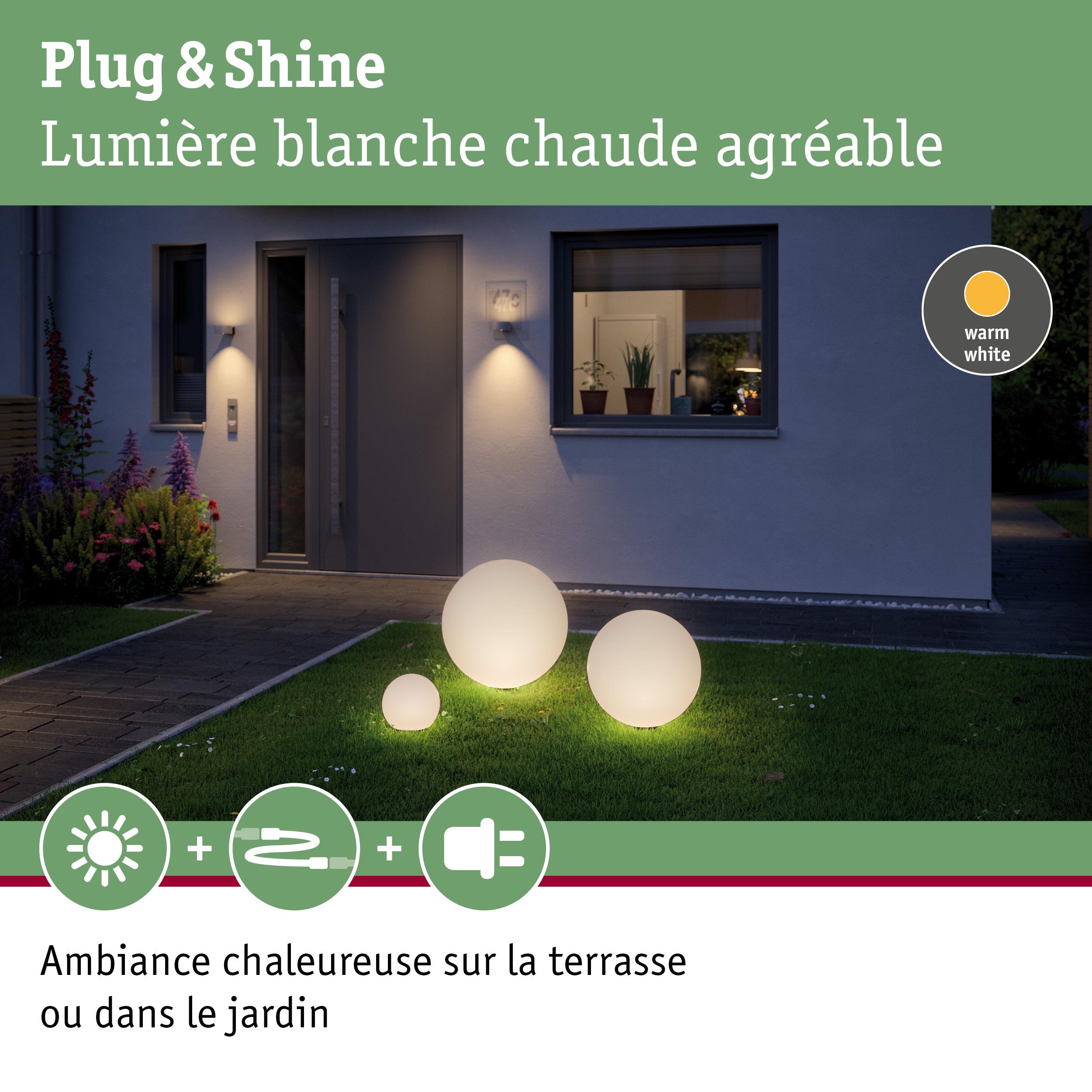 Trois lampes sphériques blanches en plastique avec lumière blanc chaud dans un jardin moderne
